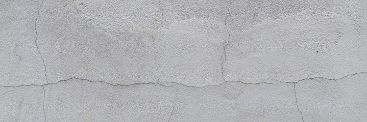 Grey concrete wall showing rough texture and surface cracks, background © Harry