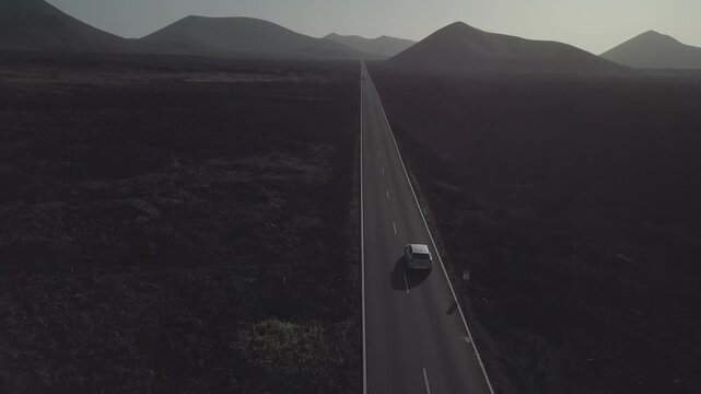 Aerial tracking shot of a car on a lava road