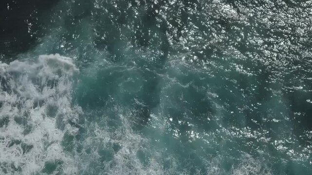 Sea foam dissolving over blue water