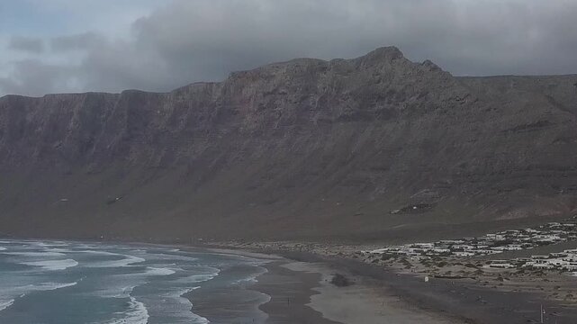 Sandy beach below steep volcanic cliffs