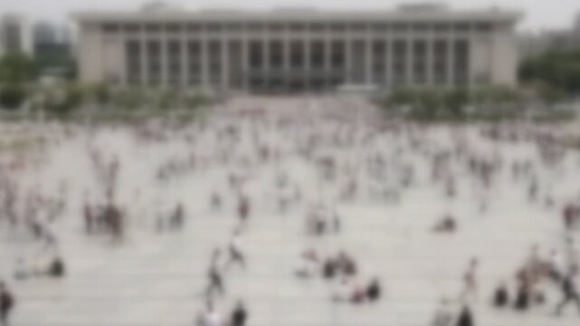 Blurred crowd crossing a broad plaza in front of a major Taipei station