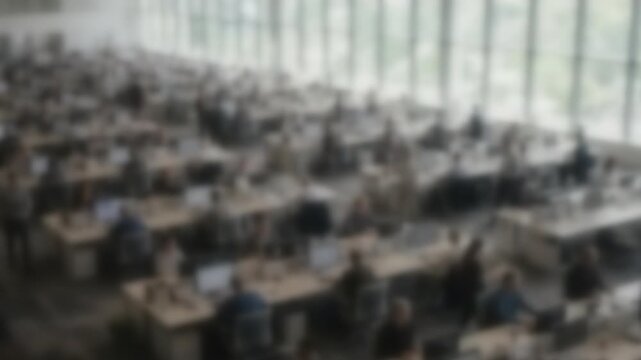 Blurred busy open plan office with every desk occupied