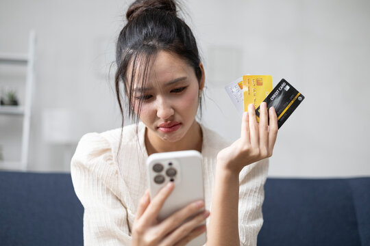 A stressed and anxious young woman holding a credit card and a stack of bills; issues related to overspending, debt management, and financial difficulties.