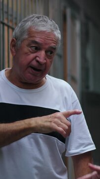 Furious senior couple exchanging angry gestures in narrow residential hallway