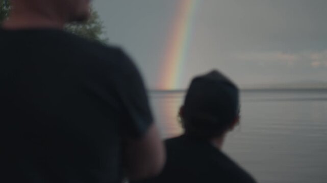 People enjoy rainbow in the sky, watch and talk something about the sky