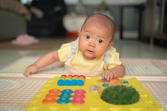 Cute Asian Baby Doing Tummy Time on Sensory Playboard