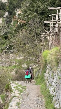 Couple hiking the Path of the Gods trail with panoramic views of the Amalfi Coast, Campania, Italy