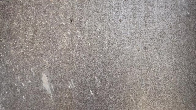 Static close up of old weathered metal surface texture. Candid locked shot of rusty metallic plate with grunge stains, scratches, and raw industrial detail.
