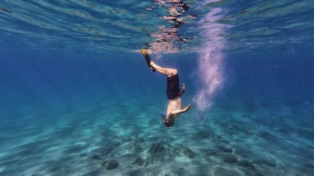Senior man freediving underwater in tropical ocean, exploring the seabed, snorkeling with mask and fins, active aging, adventure travel, marine exploration, outdoor recreation and healthy lifestyle