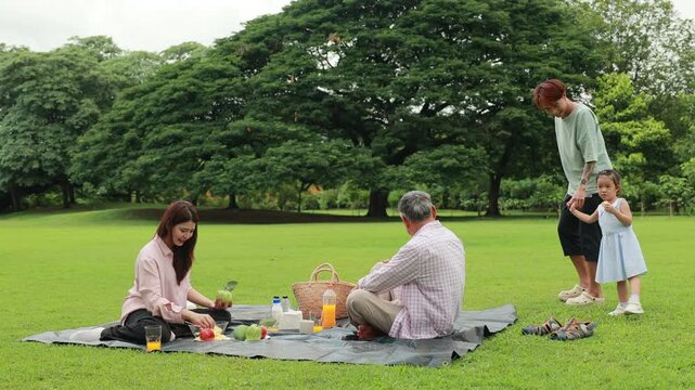 Father, Little girl walking and spending time with father in the park. Happy Asian family having fun time on picnic at city nature park, outdoor activitie