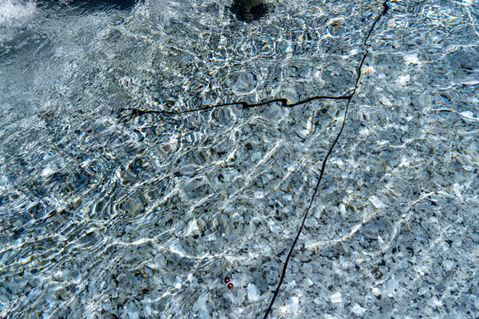 Clear water with ripples and submerged twig in riverbed