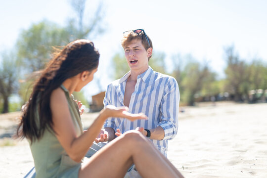 Young couple arguing on beach having relationship problems