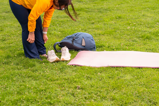 woman taking off shoes to exercise outside