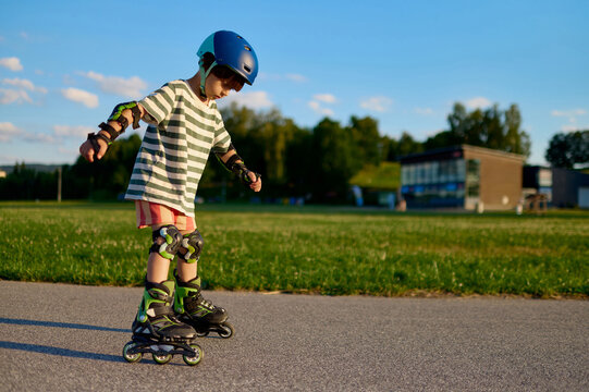 Little boy learning to roller skate in the park