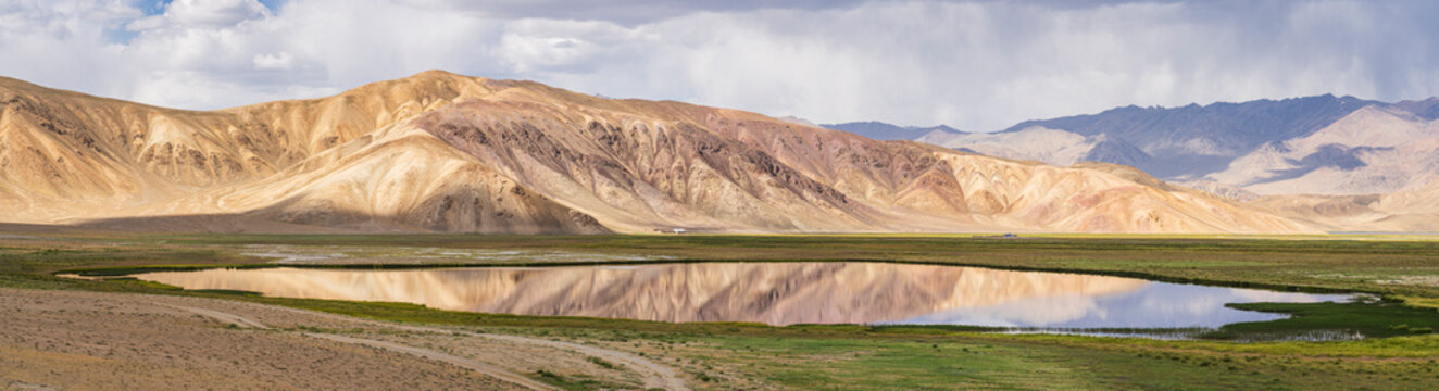 Scenic high-altitude landscape panorama of colorful mountains with reflection in lake, Bulunkul, Murghab, Gorno-Badakhshan, Tajikistan Pamir