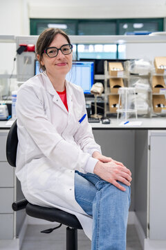 Scientist Sits on Stool in Lab During Work Hours