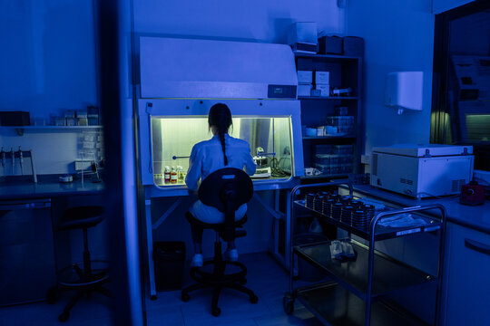 Scientist Working in a Laboratory Under Blue Light