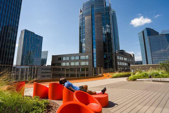 Athlete Resting Near Running Track In Modern Architecture Background