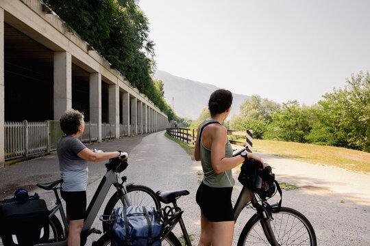 Mother and daughter pausing with bicycles in northern Italy