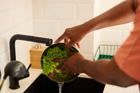 Person is washing lettuce in the sink