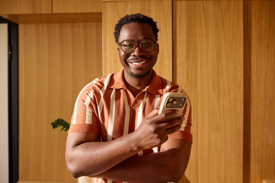Portrait of a man smiles at his phone