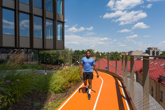 Athlete Walking In Modern Architecture Background