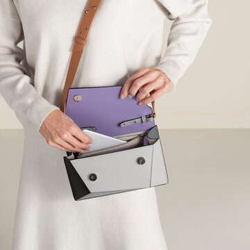 Hands Opening Purple Handbag With Neutral Sweater