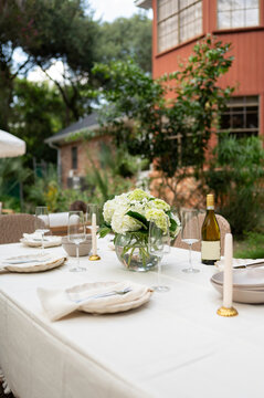 Dinner Table Set for Gathering in Outdoor Setting With Flowers