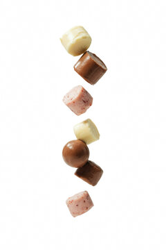 Assorted chocolate candies flying in air.