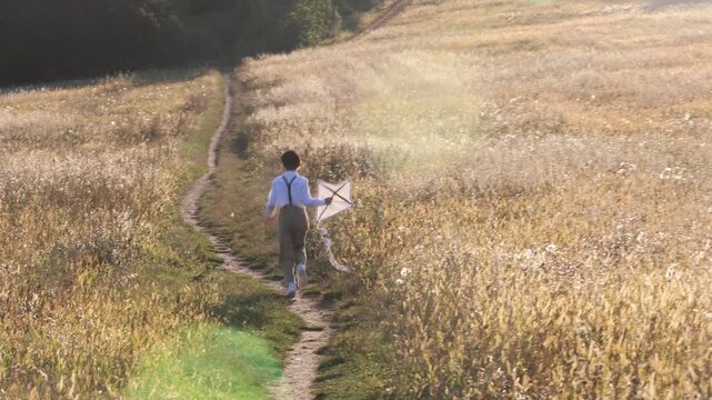 Sweet preteen child, boy, playing in a field on sunset with kite and old vingate car, walking with grandmother in the countryside