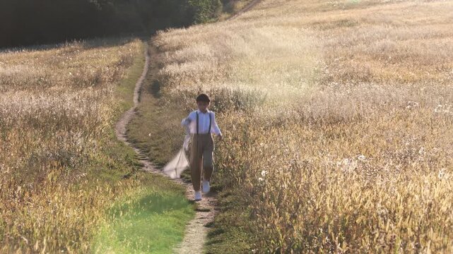 Sweet preteen child, boy, playing in a field on sunset with kite and old vingate car, walking with grandmother in the countryside