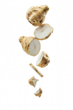 Fresh celeriac root slices falling down.