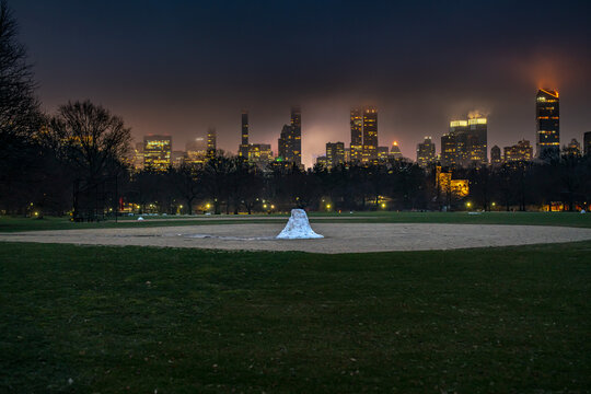Central Park snow pile baseball field March early spring New York USA
