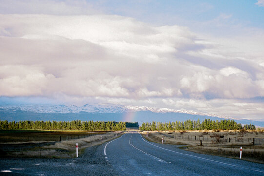 Scenic road bordered by lush trees and mountains
