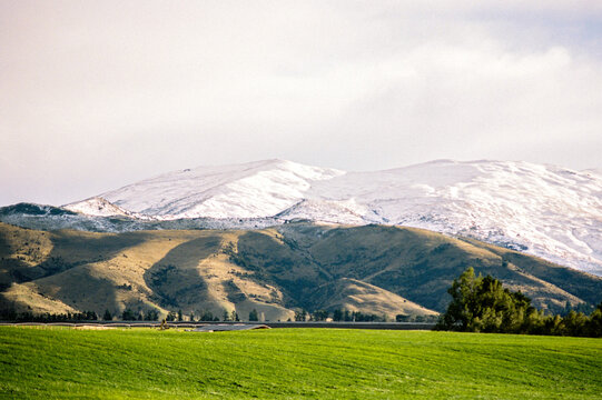 Mountains glow under soft sunlight on grassy field