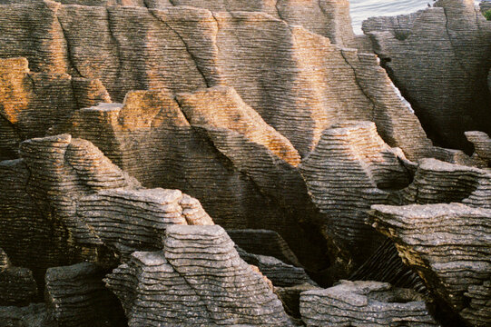 Textured Rock Formations at Sunset by the Ocean in New Zealand