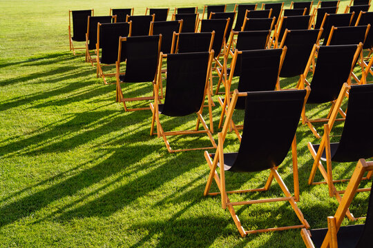Rows of Empty Black Deck Chairs on Grass