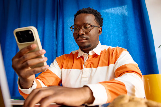 Portrait of a casual man stares at his phone while working