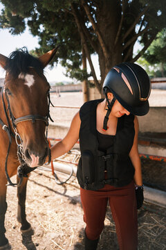 Horsewoman leading horse out of stable: equestrian lifestyle