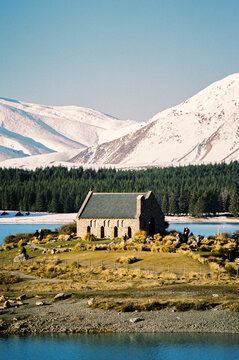 Idyllic church with lake backdrop and snow-dusted peaks