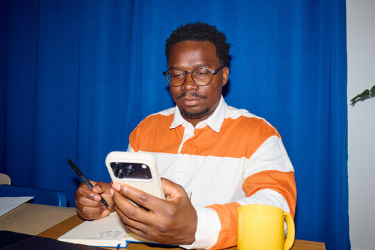 Man works from his home, looking at the phone