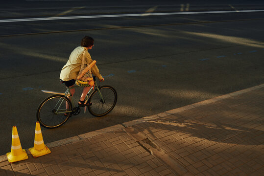 Woman rides a bicycle away during golden hour