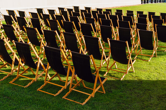 Rows of Empty Black Deck Chairs on Grass