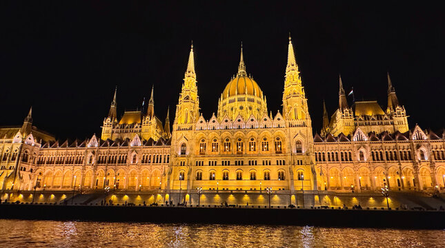 Beautiful view of Hungarian Parliament Building along the Danube River at night in Budapest, Hungary