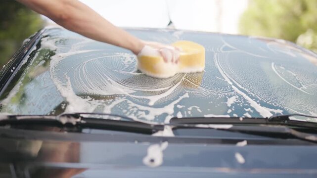 Washing a car with a soft sponge and rich foam close-up