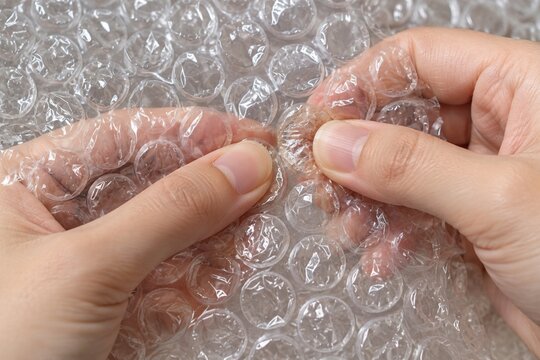 Hands pressing bubble wrap