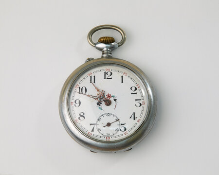 Vintage silver pocket watch with an ornate white dial, floral details, and a sub-seconds hand, isolated on a white background. Perfect for antique timepieces concept.