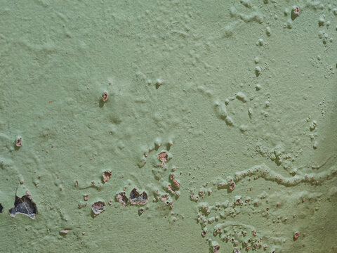 blistered and peeling green paint on a weathered wall surface. Target: abstract textural backgrounds, urban decay concepts, and architectural renovation templates
