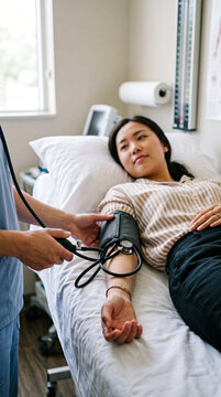 Close-up hands of nurse measuring blood pressure of patient