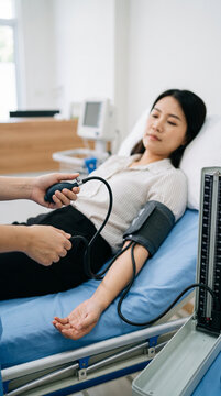 Close-up hands of nurse measuring blood pressure of patient